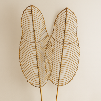 Decorative wire leaf sculpture in a white vase against a beige background